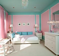 a bedroom with pink and blue walls, white dressers and a bed in it