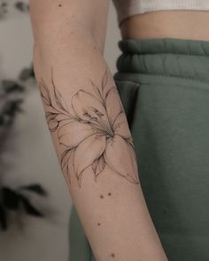 a woman's arm with a flower tattoo on the left side of her arm