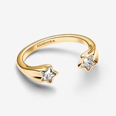 Elevate your style with the Shooting Stars Open Ring, crafted from our 14k gold-plated unique metal blend. This eye-catching piece features two star-cut clear cubic zirconia, each positioned at the ends of an open band adorned with a delicate shooting stars motif. Inspired by the idea that the world shines brighter when we’re with loved ones, it’s perfect for stacking with other rings or wearing solo for a celestial statement. Pair it with a simple bracelet for a festive look. - Pandora Shooting Stars Open Ring - 14k Gold-plated unique metal blend / Cubic Zirconia / Clear - Sz. 4.5 Pandora Rings Gold, Pandora Star Ring, Charms Disney, Pandora Star, Pandora Essence, Pandora Gold, Festive Look, Pandora Rings, Simple Bracelets