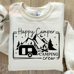 a white shirt with the words happy camper camping crew printed on it and an rv in the background