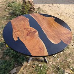 a wooden table sitting on top of a grass covered field