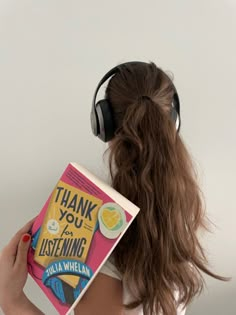 a woman wearing headphones holding a book with the title, thank you for listening