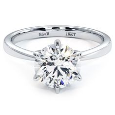 an engagement ring with a round brilliant cut diamond in the center, on a white background