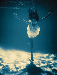 a woman in white dress under water