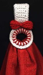 a red and white knitted object with a ring on it's end, sitting on a black surface