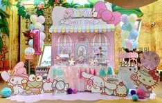 a pink hello kitty sweet shop with balloons and decorations