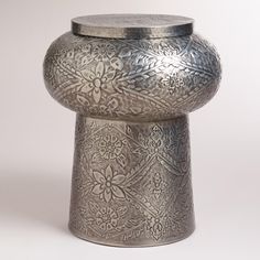 a silver vase sitting on top of a white table