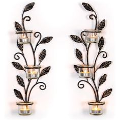 two metal wall sconces with candle holders on each side and leaves in the middle