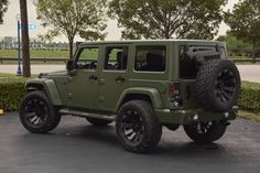 a green jeep parked in a parking lot