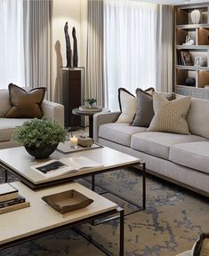 a living room filled with lots of furniture next to a window covered in white curtains