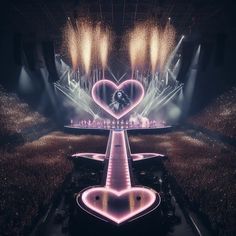 the stage is lit up with lights and heart shaped shapes in front of an audience