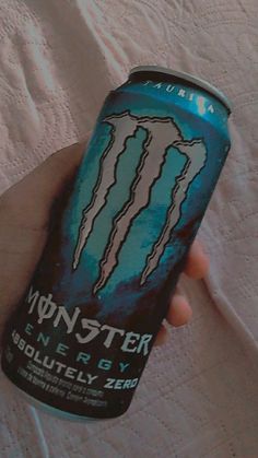 a can of monster energy drink in someone's hand