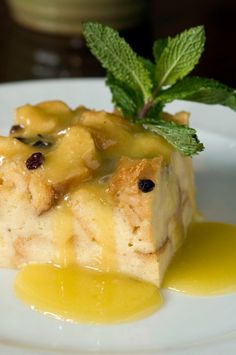 a piece of cake sitting on top of a white plate covered in syrup and garnish