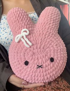 a woman holding a pink stuffed animal in her hands