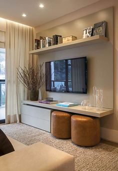 a living room filled with furniture and a flat screen tv mounted on a wall next to a window