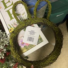 a person holding up a fake bunny head made out of grass and moss with a price tag on it