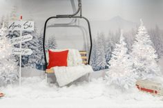 a snow scene with a ski lift in the background and christmas decorations on the ground