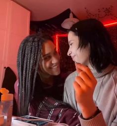 two young women sitting at a table together