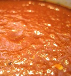 a pot filled with red sauce sitting on top of a stove