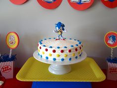 a birthday cake with a sonic the hedgehog figure on top and cupcakes