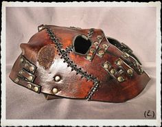 This unique and fully handmade mask is made of 6-7 oz veg tanned leather dyed with a warm dark-brown, treated with a leather satin acrylic finisher. Leather straps, black stiches and bronze plated rivets adorns this creation. The buffalo leather strap have a roll buckle made from steel and brass plated. It's long enough to any size of head or top hat, attached to the frame with brass plated rivets. Extralong straps are available, just ask for it. If you have any question or want something simila Handmade Mask, Leather Mask, Leather Dye, The Buffalo, Veg Tan Leather, Buffalo Leather, Top Hat, Rivets, Tan Leather