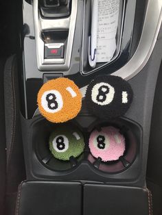 three balls in the center console of a car with numbers 8 on each side and eight on the other