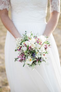 a bride holding a bouquet of flowers in her hands