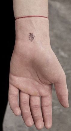 a person's hand with a small tattoo on it