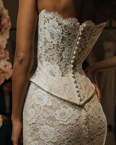 the back of a woman's wedding dress, with buttons on the bustle