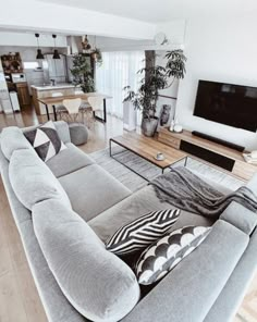 a living room filled with furniture and a large flat screen tv mounted to the wall