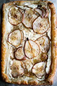 an apple and cheese tart is shown in a square dish on a table top