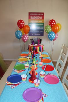 the table is set for a rainbow birthday party