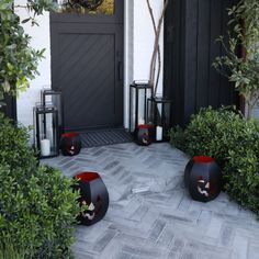 halloween decorations on the front steps of a house with black and red pumpkins in them