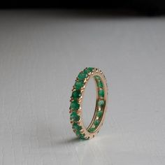 Gorgeous Emerald Eternity ring in your choice of Karat and Gold Color. Featuring between 2.35-2.52ctw (Subject to size). Natural Grade AAA Emeralds with that wonderful sought after green and Very Good clarity. Each ring is made to Order and set with meticulously handpicked Emeralds to ensure the most elegant results. All questions and custom requests welcome!, Fast turn around. ----------------------DIMENSIONS---------------------- This rings shank is 3.4 mm to accommodate the 3 mm Emeralds. The Green Emerald Eternity Ring, Green Eternity Band With Vvs Clarity In Round Shape, Classic Green Eternity Band, Classic Green Round Eternity Band, Round Emerald Eternity Band With Prong Setting, Green Emerald Wedding Band, Gold And Emerald Ring, Gemstone Wedding Band, Emerald Gold Ring