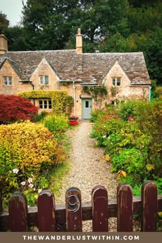 an old country house surrounded by flowers and greenery with a wooden fence in the foreground