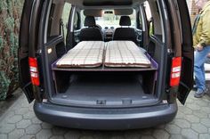 the back end of a van with two mattresses in it