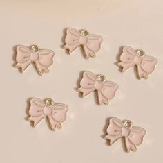 six pink bow charms sitting on top of a table