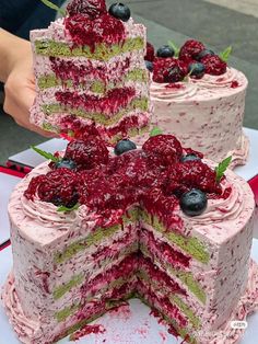 the cake is decorated with raspberry and blueberries