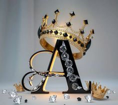 the letter a is surrounded by jewels and gold crownes on a gray background with diamonds scattered around it