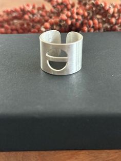 A modern  ring with a unique design- a great statement ring! The simple wide band shape of the ring  has a circular cut out - a truly unique design! The ring is adjustable and a size 8 as shown. It is 5/8 of an inch wide. Wide Band Ring, Modern Ring, Wide Band Rings, Wide Bands, Adjustable Ring, Adjustable Rings, Statement Ring, Band Ring, Band Rings