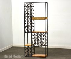 a tall metal and wood shelf with baskets on it's sides, against a white wall