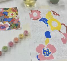 the table is covered with art supplies such as watercolors and paper flowers on it