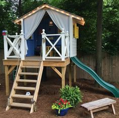 there is a play house with a slide in the yard