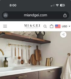 a kitchen counter with wooden utensils hanging on the wall