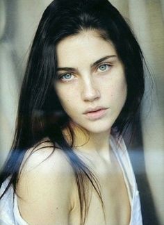 a woman with long dark hair and blue eyes