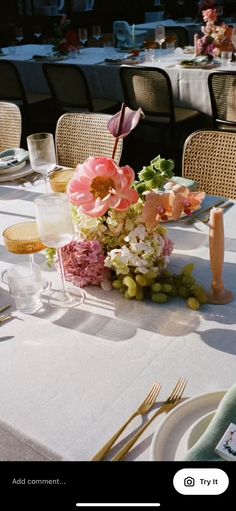 the table is set with flowers and place settings for an elegant dinner or reception party