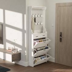 a white shoe rack in the corner of a room next to a door with shoes on it