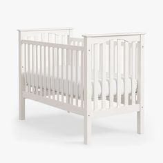 a white crib is shown with no mattress