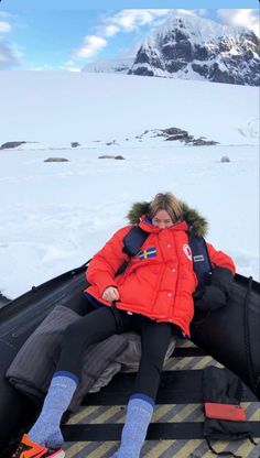 a woman sitting on top of a snow covered ground