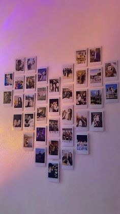 a bunch of pictures hanging on the wall with purple lights in the room behind them